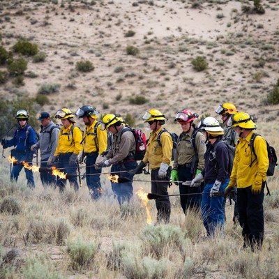 Firefighters holding fire torches in desert
