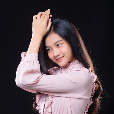 Asian woman touching hair on black background