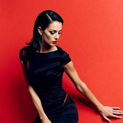 Woman in black dress against red background