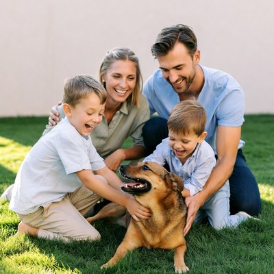 Happy family playing with dog on grass