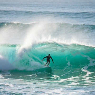 Surfer riding massive ocean wave