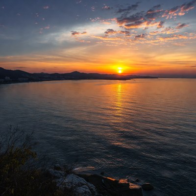 Sunset over ocean with mountains