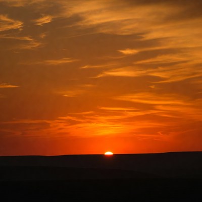 Sunset over horizon with orange clouds