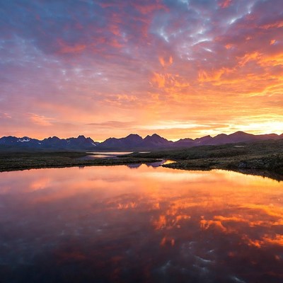 Sunset over mountains reflecting in lake