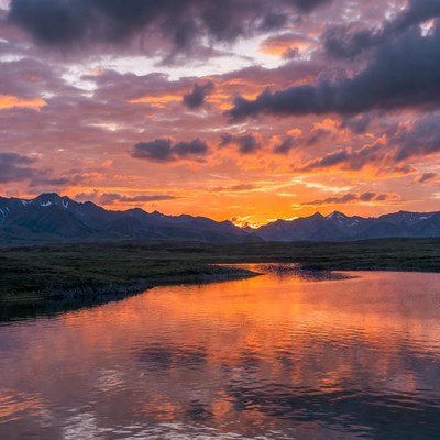 Sunset over mountains and reflective lake