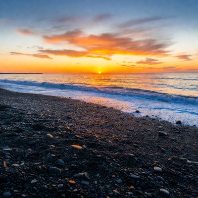 Sunset over pebbly beach