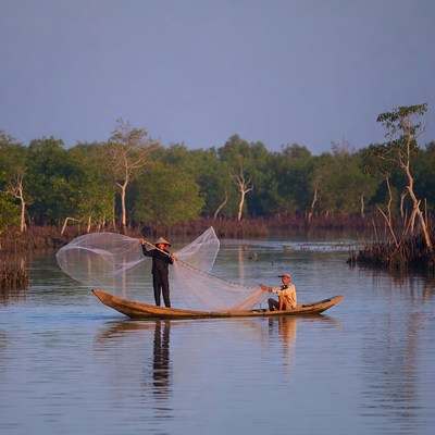 Two Asian fishermen casting net from boat