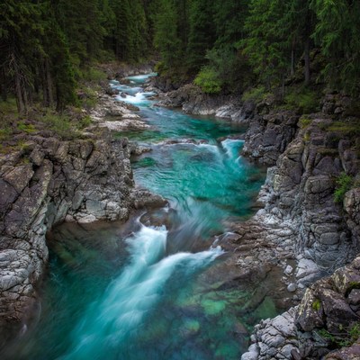 Turquoise River Flowing Through Forest Canyon