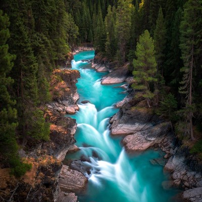 Turquoise River Flowing Through Forest Canyon