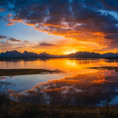 Sunset over mountains reflecting in lake