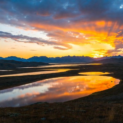 Sunset over mountains and reflective lakes