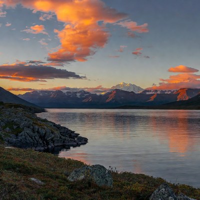 Sunset over snowy mountains and lake