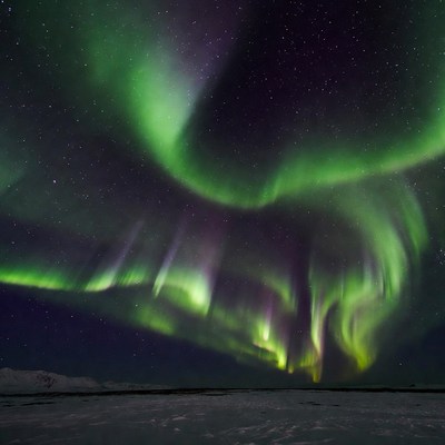 Vibrant Northern Lights over Snowy Landscape