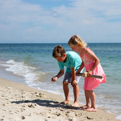 Boy and girl playing with shells on beach