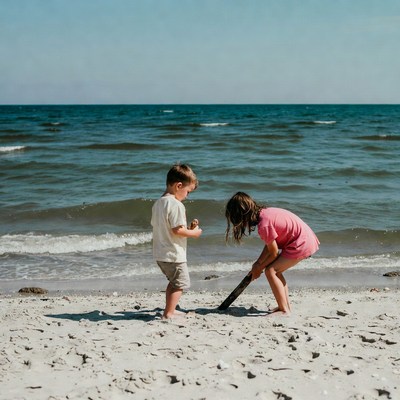 Boy and girl playing with stick on beach