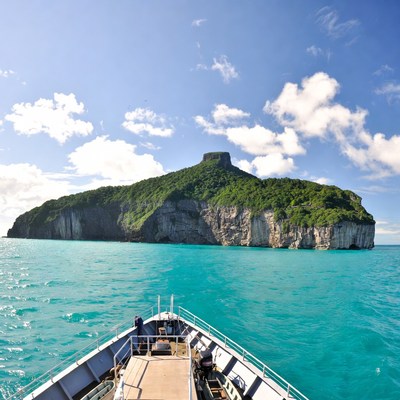 Boat Approaching Green Tropical Island
