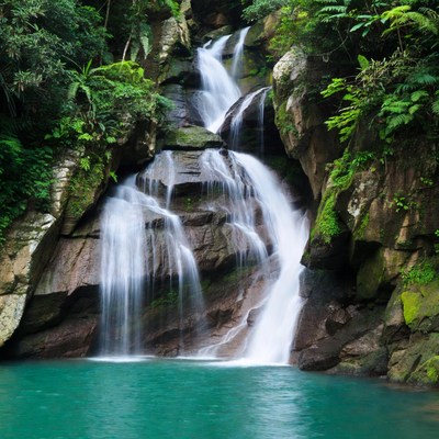 Waterfall cascading into turquoise pool
