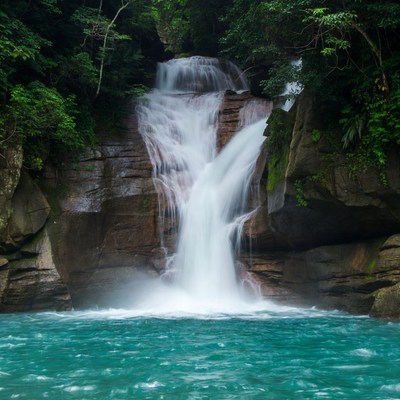 Waterfall cascading into turquoise pool