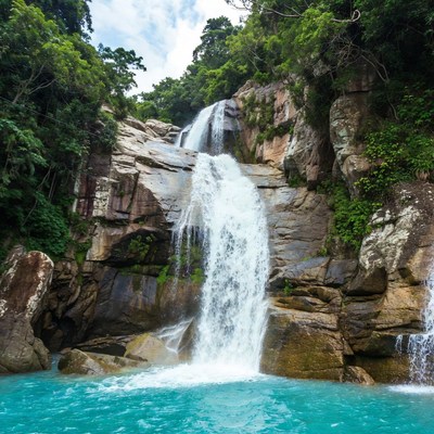 Tropical Waterfall Cascading into Turquoise Pool