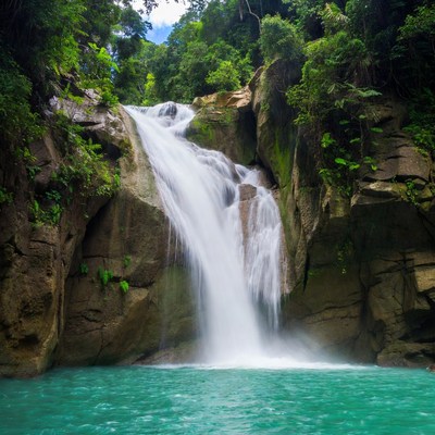 Waterfall cascading into turquoise pool