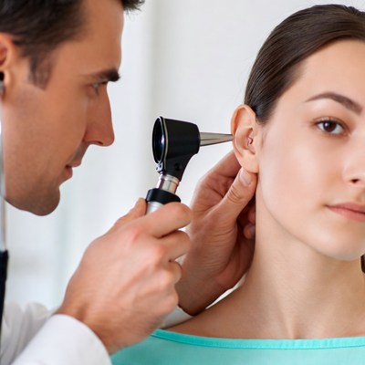 Doctor examining woman's ear