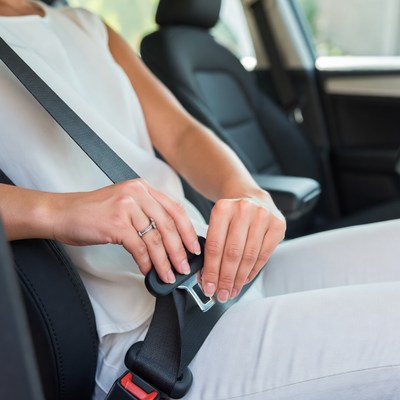 Woman buckling seatbelt in car