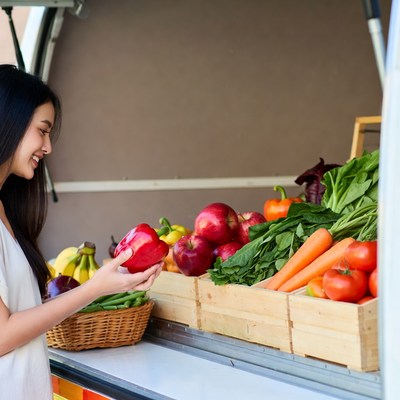 Asian woman holding red bell pepper