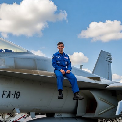 Man in blue jumpsuit on fighter jet