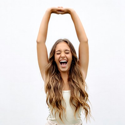 Young woman raising arms laughing