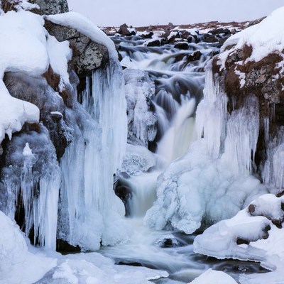 Frozen Waterfall in Snowy Rocks