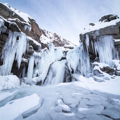Frozen Waterfall in Snowy Mountains