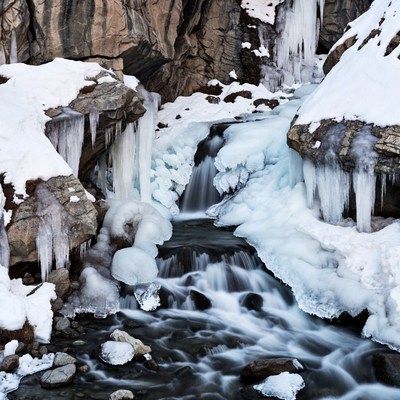 Frozen Waterfall in Snowy Rocks