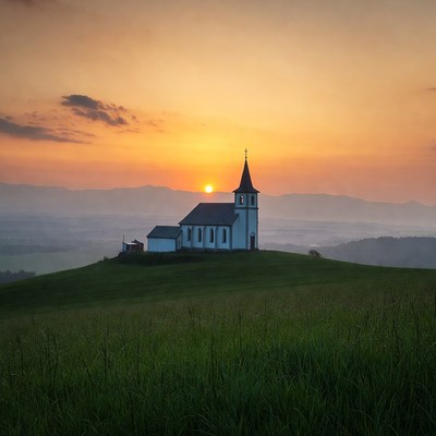 Small church on hill at sunset