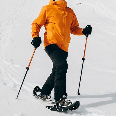 Man snowshoeing in orange jacket