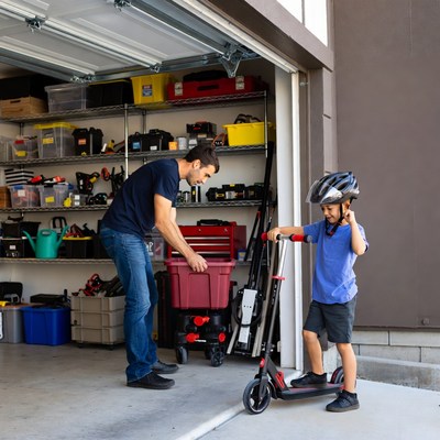 Father helping son with scooter in garage