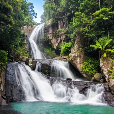 Tropical Waterfall Cascading into Turquoise Pool