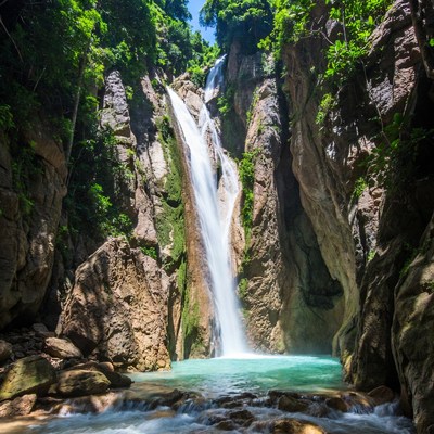 Majestic waterfall in lush green canyon