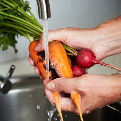 Hands washing carrots and radishes