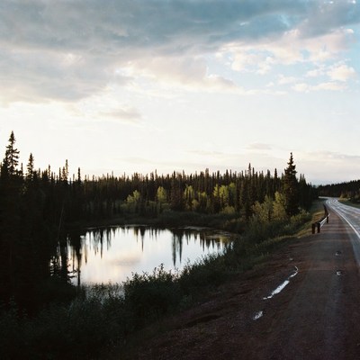 Small lake beside highway with pine forest