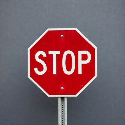 Red Stop Sign on Gray Wall