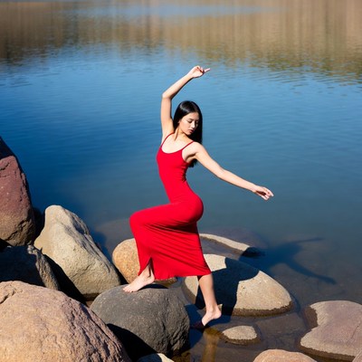 Asian woman dancing by lake