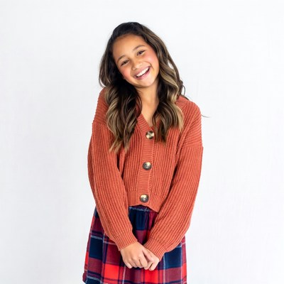 Smiling mixed-race girl in cardigan skirt