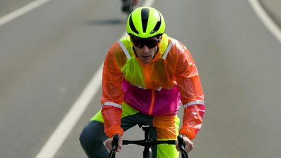 Cyclist in neon rain jacket riding bike