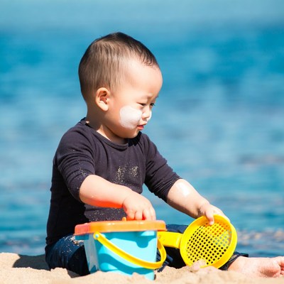 Asian baby boy playing with beach toys
