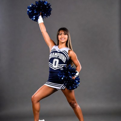 Cheerleader posing with blue pom poms