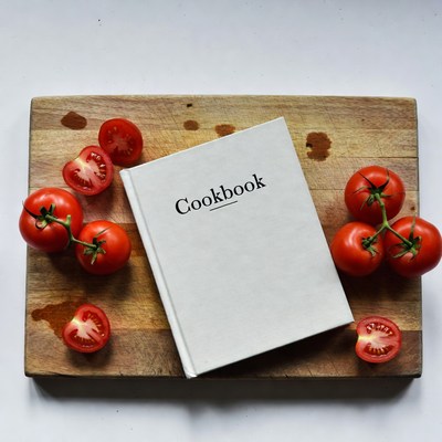 Cookbook with Tomatoes on Wooden Board