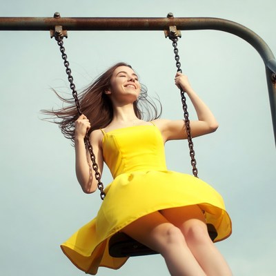 Woman swinging on yellow dress swing