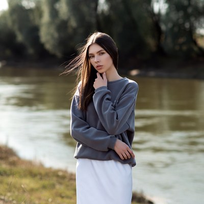 Woman in gray sweater by river