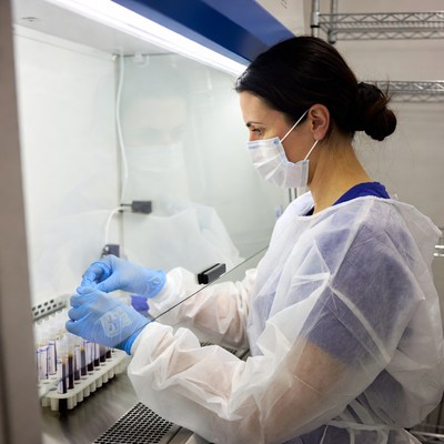 Woman handling test tubes in biosafety cabinet
