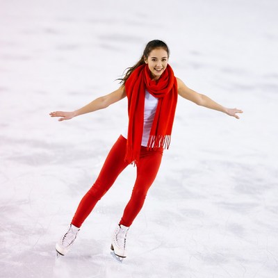 Asian woman ice skating with red scarf